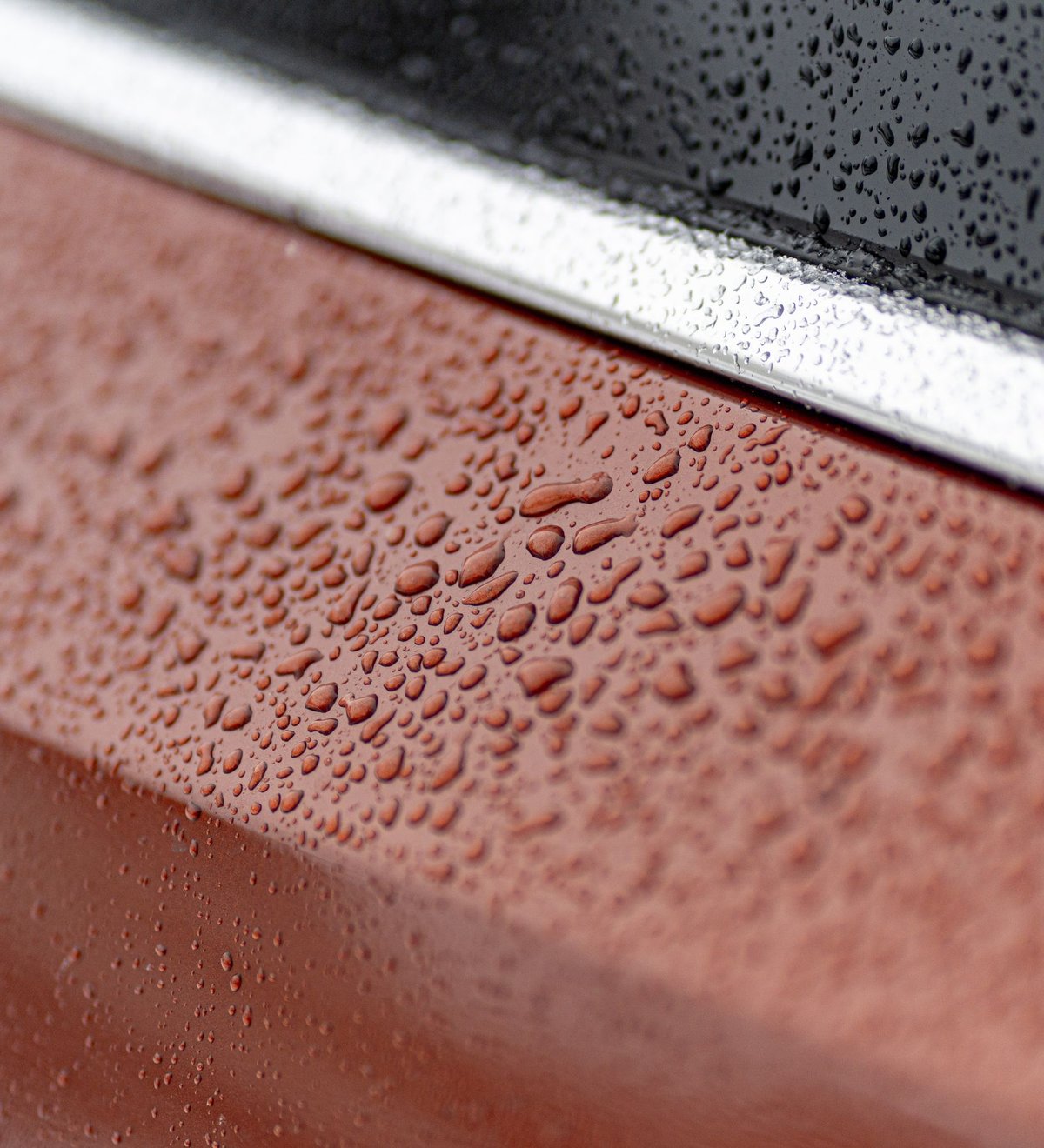 Car with a glossy ceramic-coated finish and beading water droplets